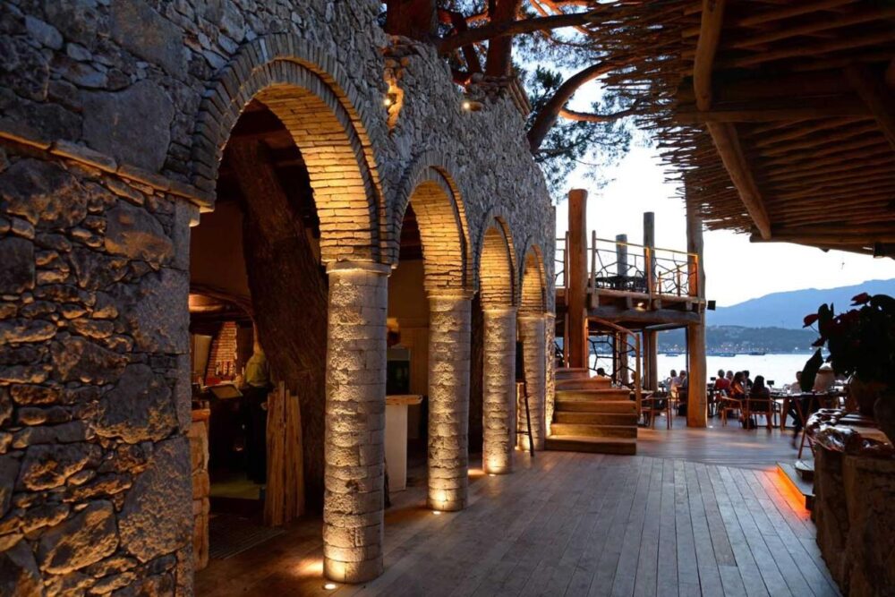 Restaurant en bord de mer avec arcades illuminées.