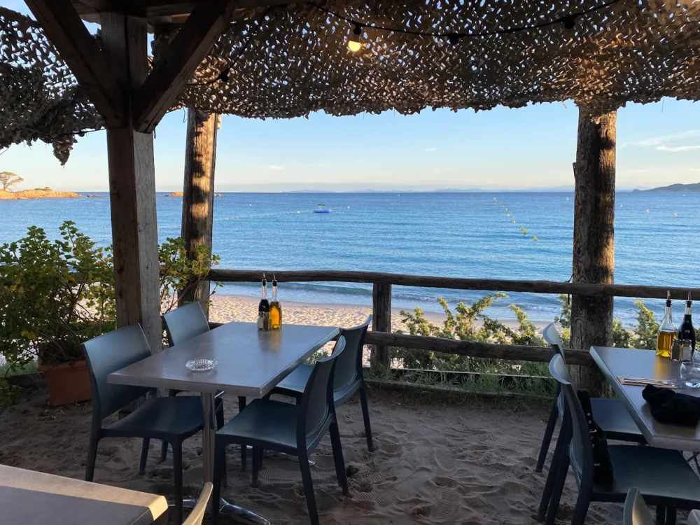 Terrasse vue mer avec tables et chaises.