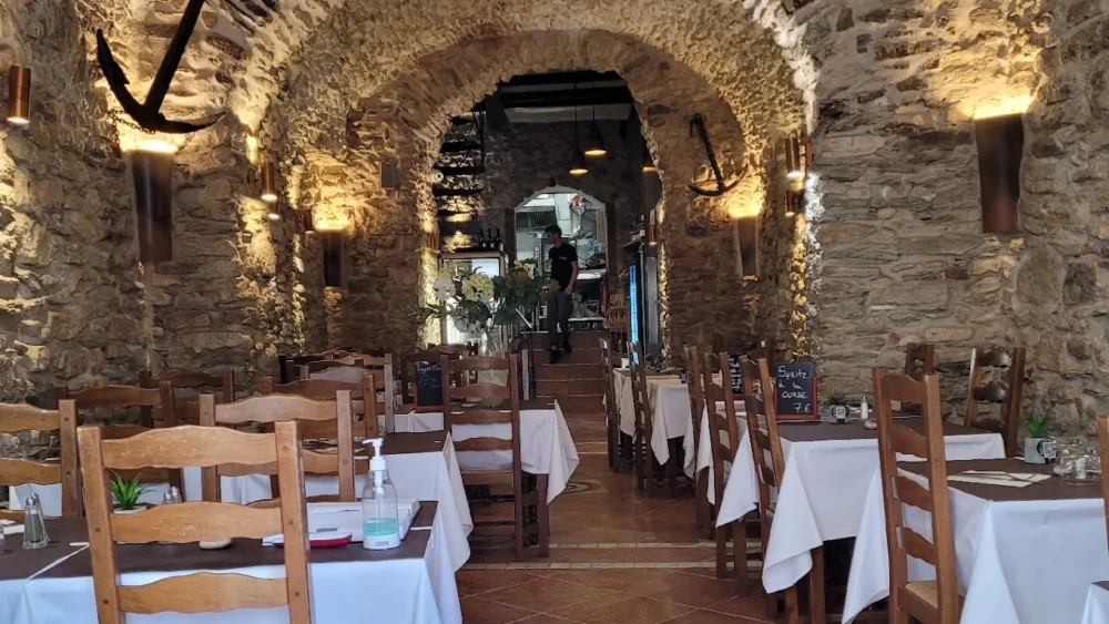 Restaurant avec murs en pierre et tables dressées.