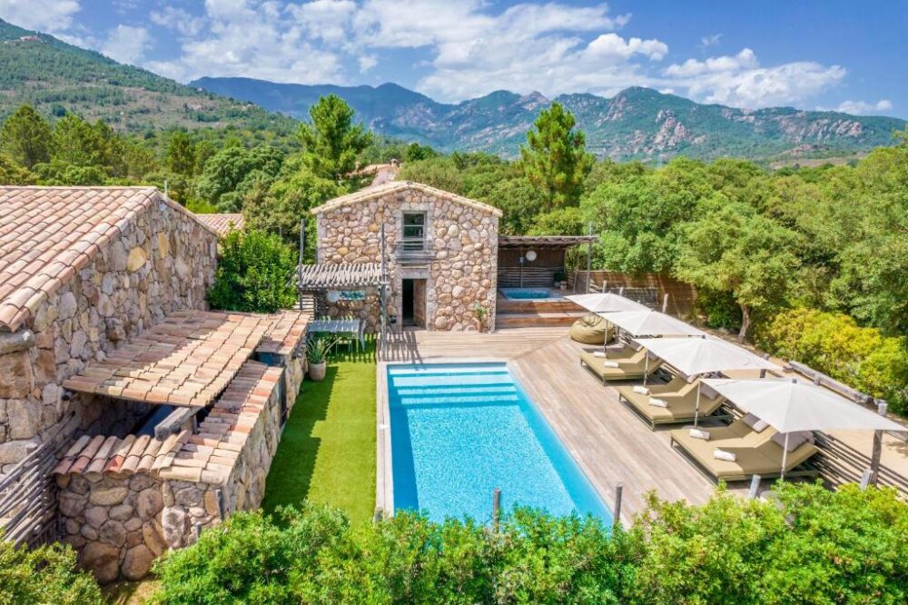Villa en pierre avec piscine et vue montagne.