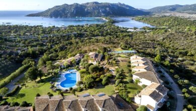 Vue aérienne d'un complexe avec piscine et nature.