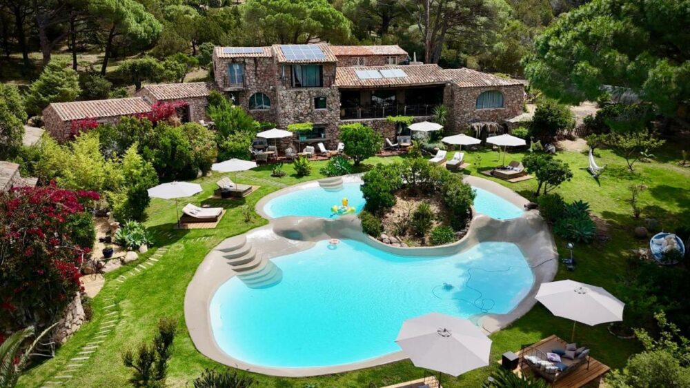 Villa en pierre avec piscine et jardin luxuriant.