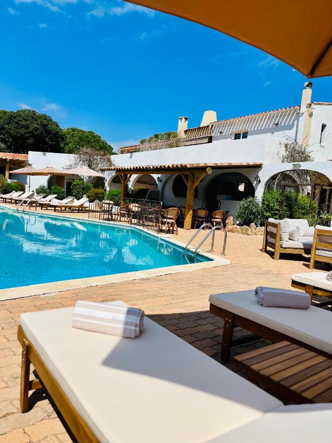 Piscine extérieure avec chaises longues et parasols.