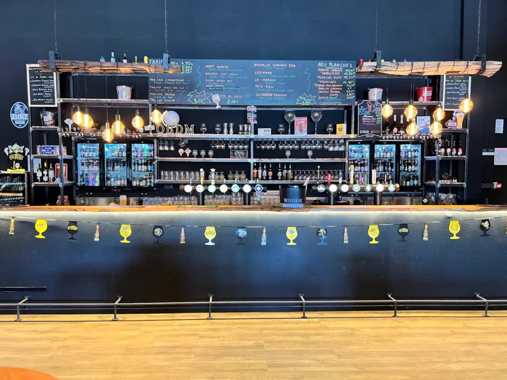 Bar moderne avec étagères et luminaires décoratifs.