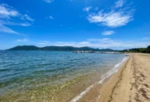 Plage de sable avec mer et ciel bleu.