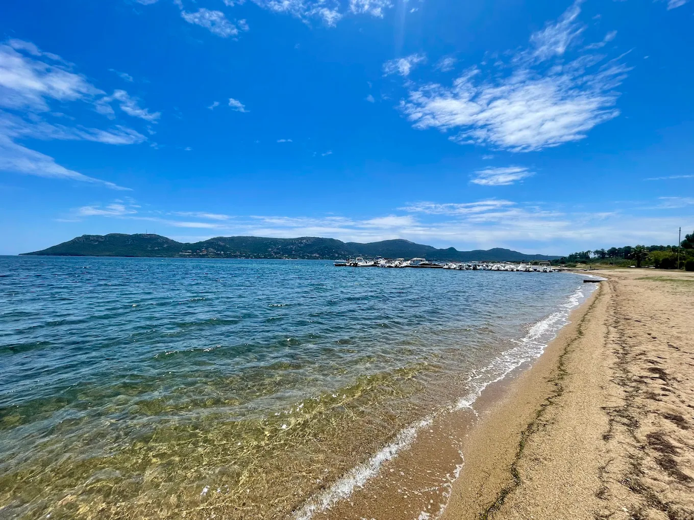 Plage de sable avec mer et ciel bleu.