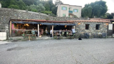 Terrasse de café en pierre, campagne verdoyante.