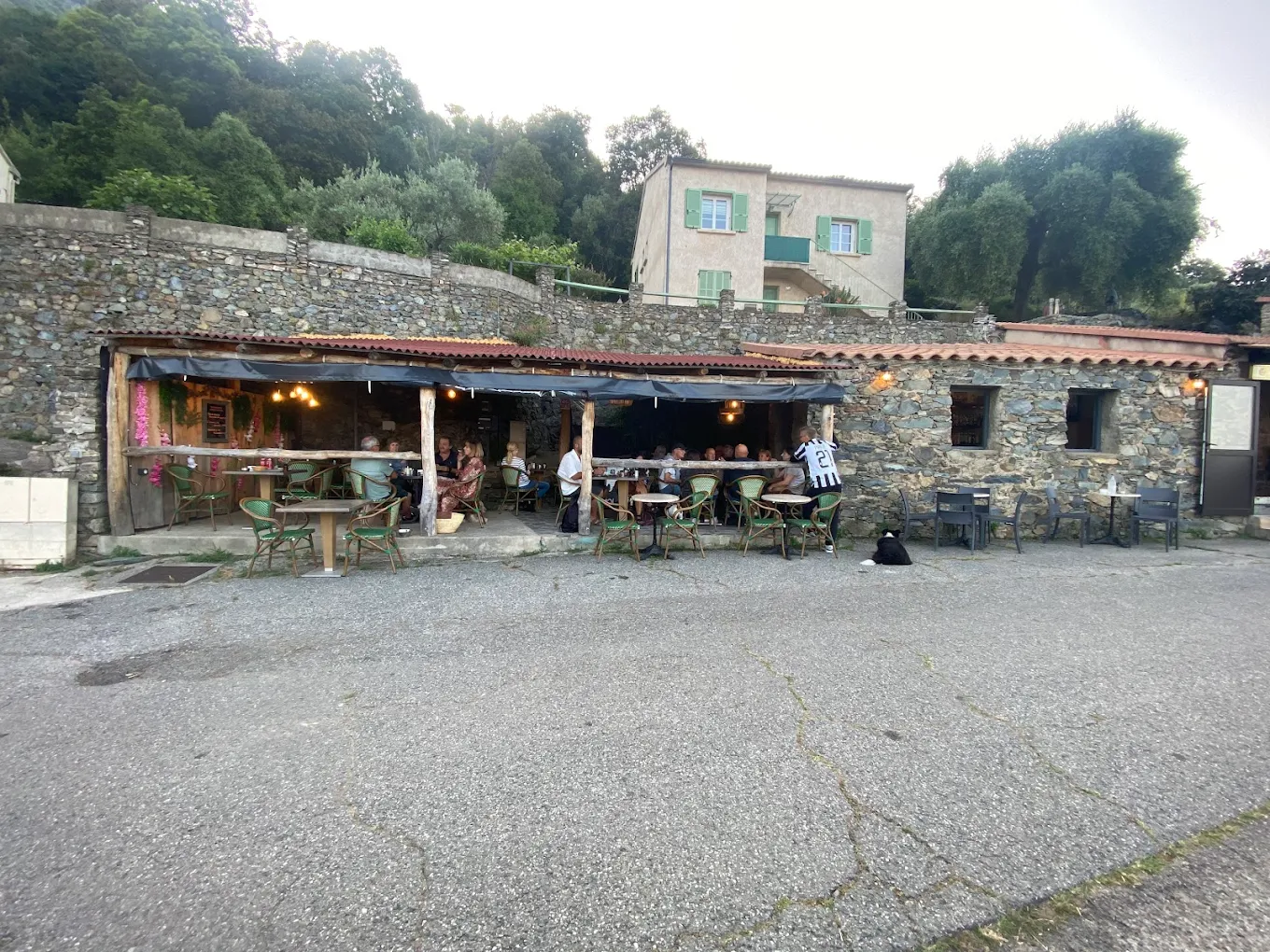 Terrasse de café en pierre, campagne verdoyante.