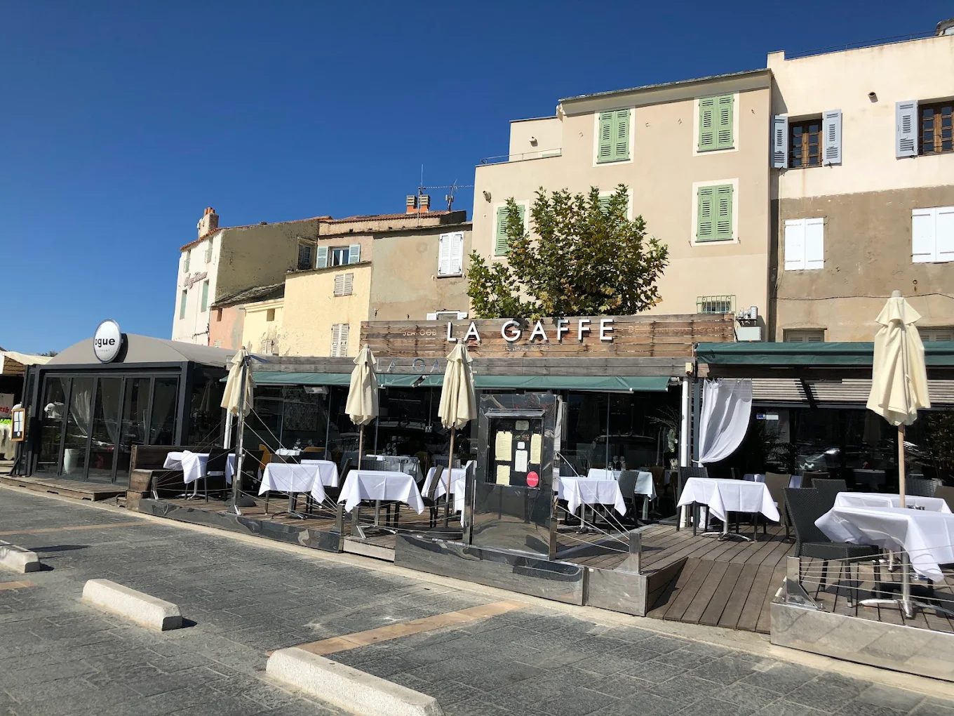 Terrasse de restaurant vide sous le soleil.
