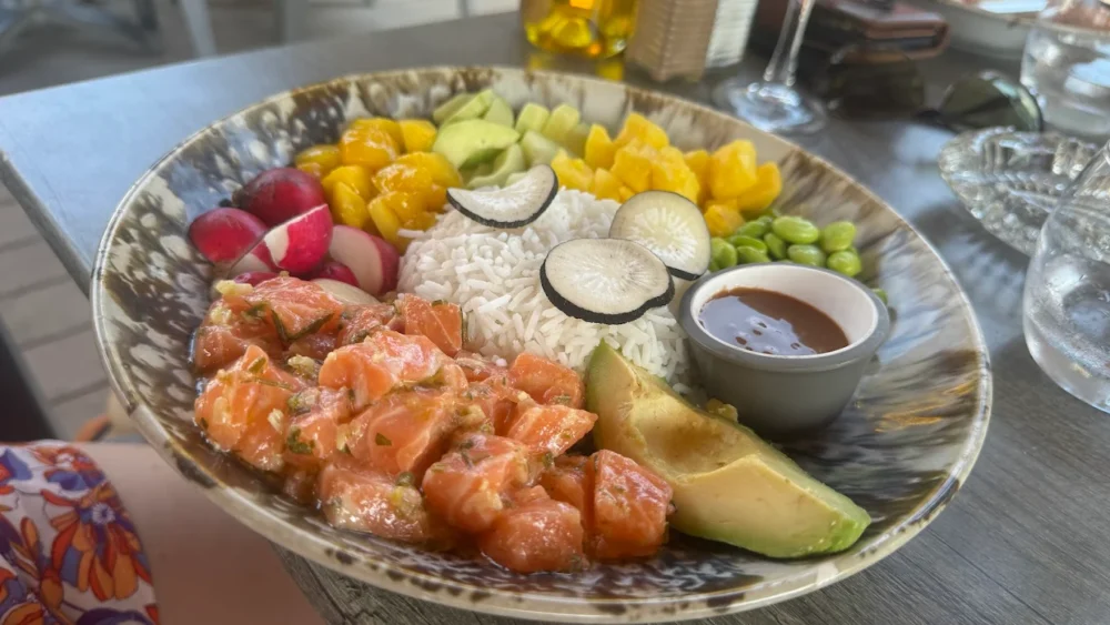 Bol poké avec saumon et légumes colorés.