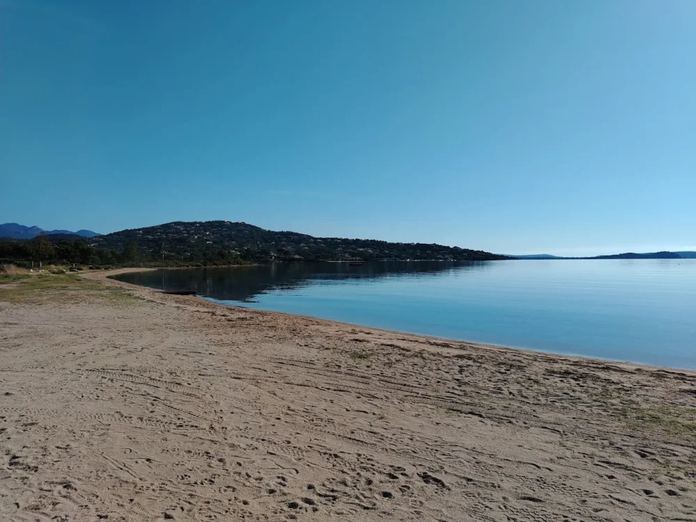 Plage déserte au bord d'une mer calme.