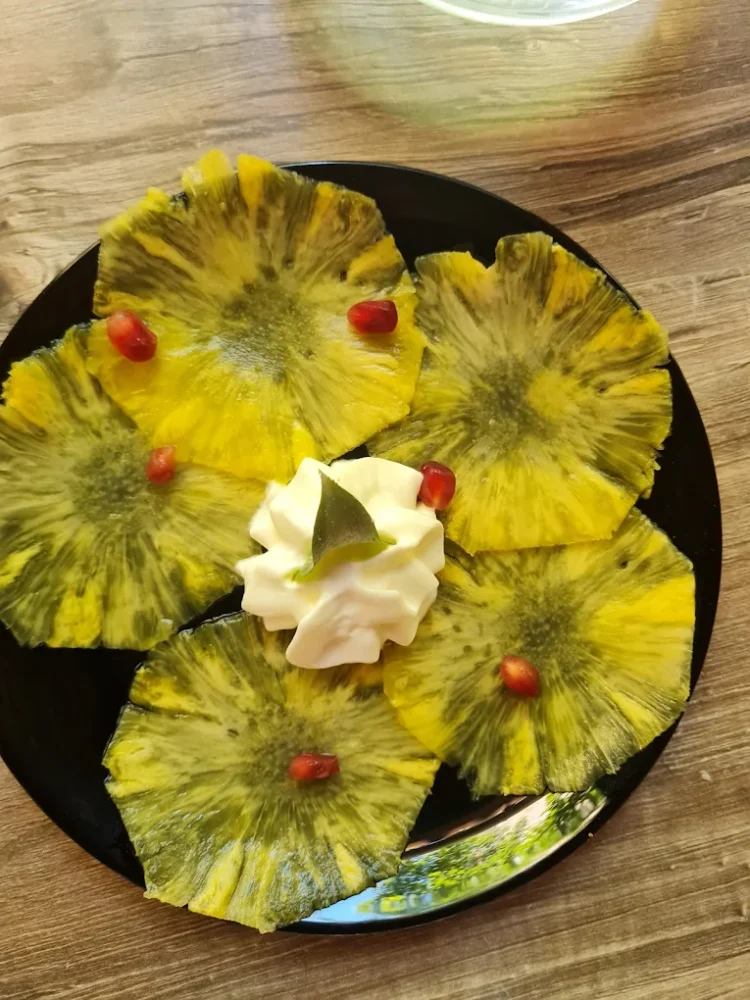 Tranches d'ananas avec crème et fruits rouges.