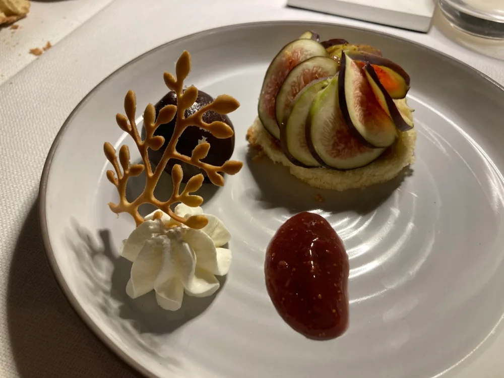 Dessert élégant avec figues et crème blanche décorative.