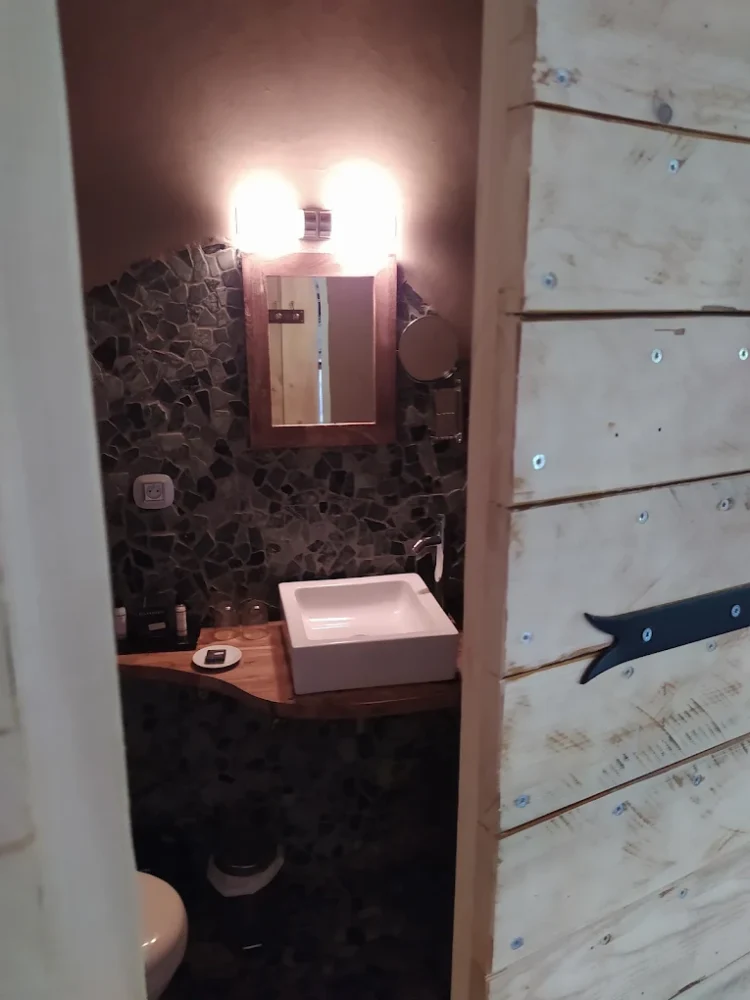 Salle de bain avec lavabo et miroir éclairé.