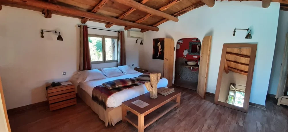 Chambre rustique avec lit double et décoration en bois.