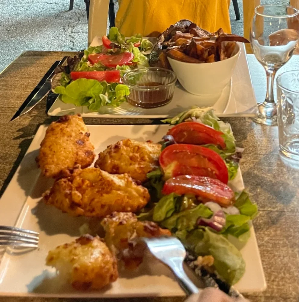 Assiette de salade et beignets sur une table.
