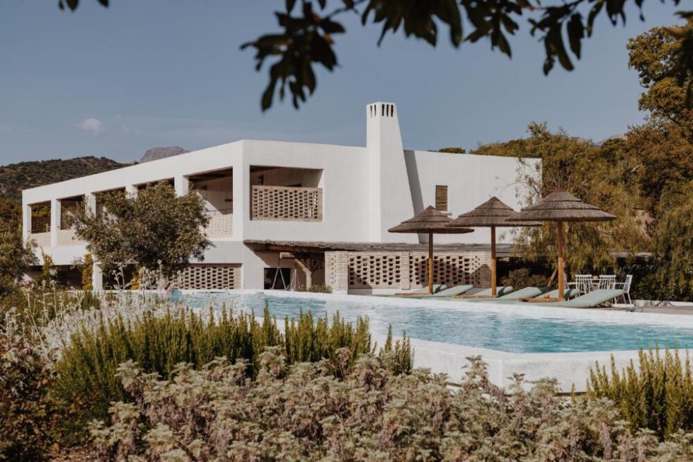 Maison moderne avec piscine et parasols.
