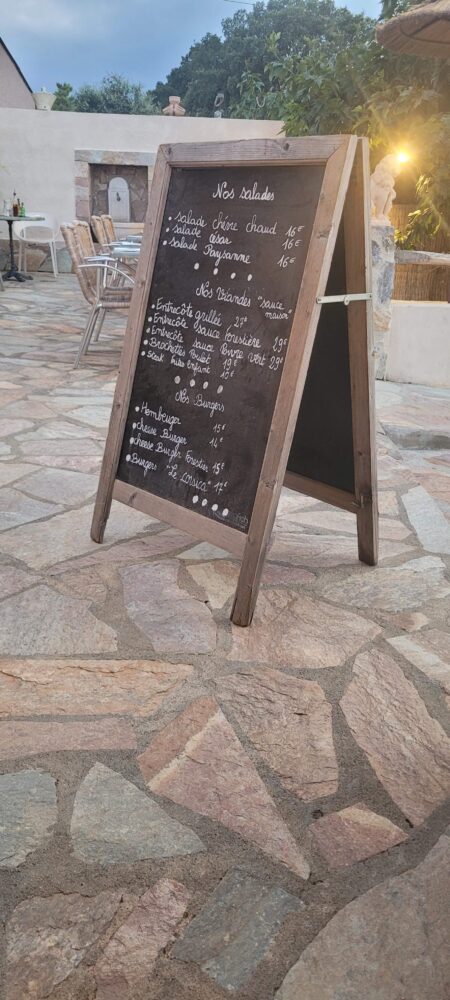 Ardoise de menu avec salades, viandes, burgers.