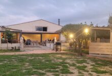 Restaurant extérieur avec terrasse éclairée au crépuscule.