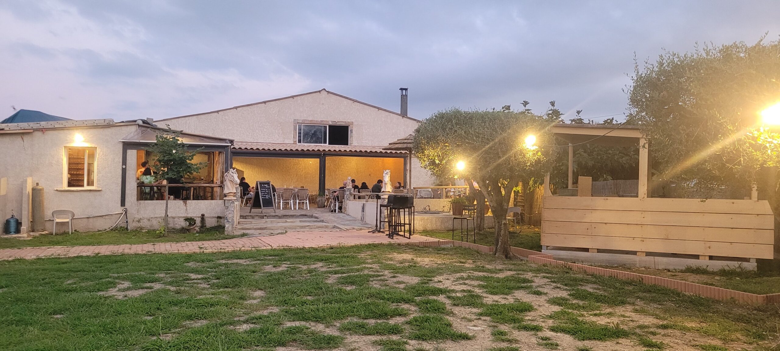 Restaurant extérieur avec terrasse éclairée au crépuscule.