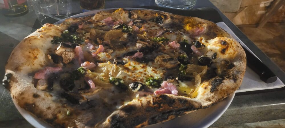 Pizza garnie aux champignons et olives noires.