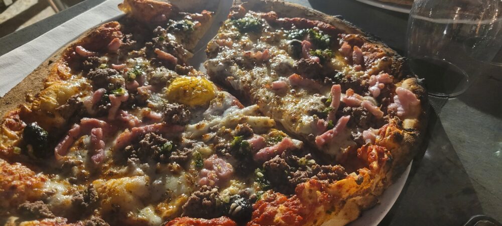 Pizza avec viande, fromage, légumes.