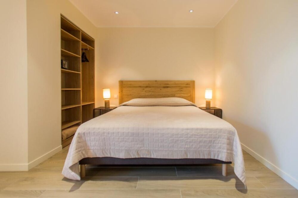 Chambre avec lit double et placard ouvert.