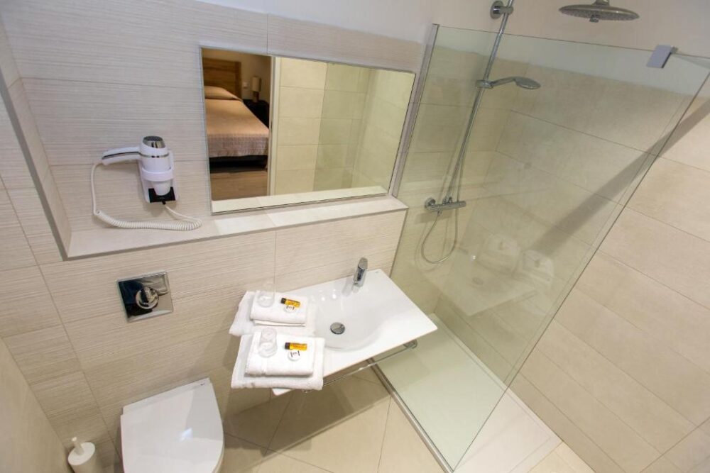 Salle de bain moderne avec douche et lavabo.
