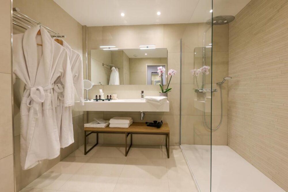Salle de bain moderne avec peignoirs et orchidées.