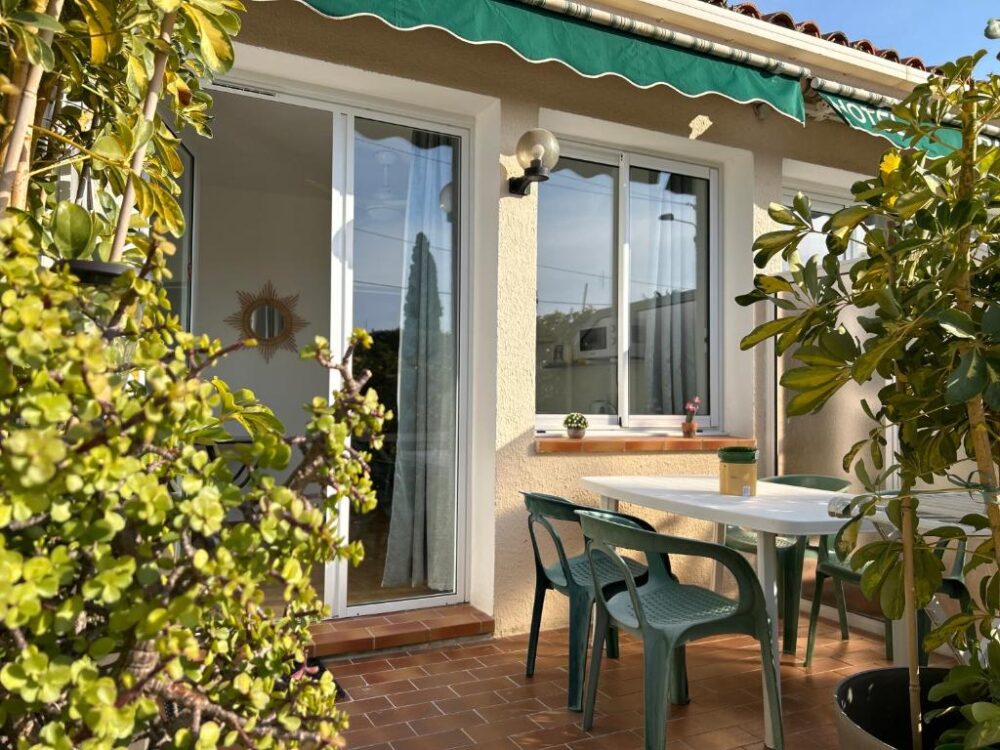 Terrasse ensoleillée avec table et chaises.