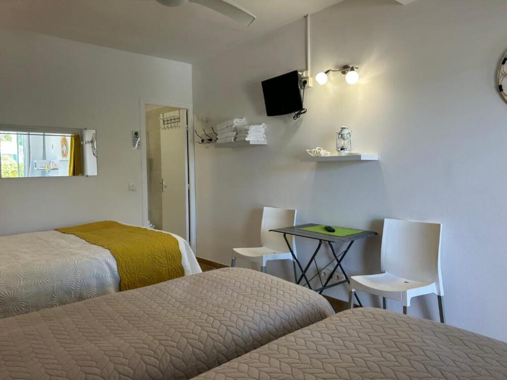 Chambre d'hôtel moderne avec lits et table.