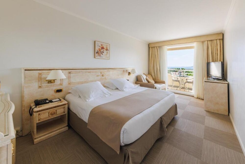 Chambre d'hôtel lumineuse avec vue sur balcon.