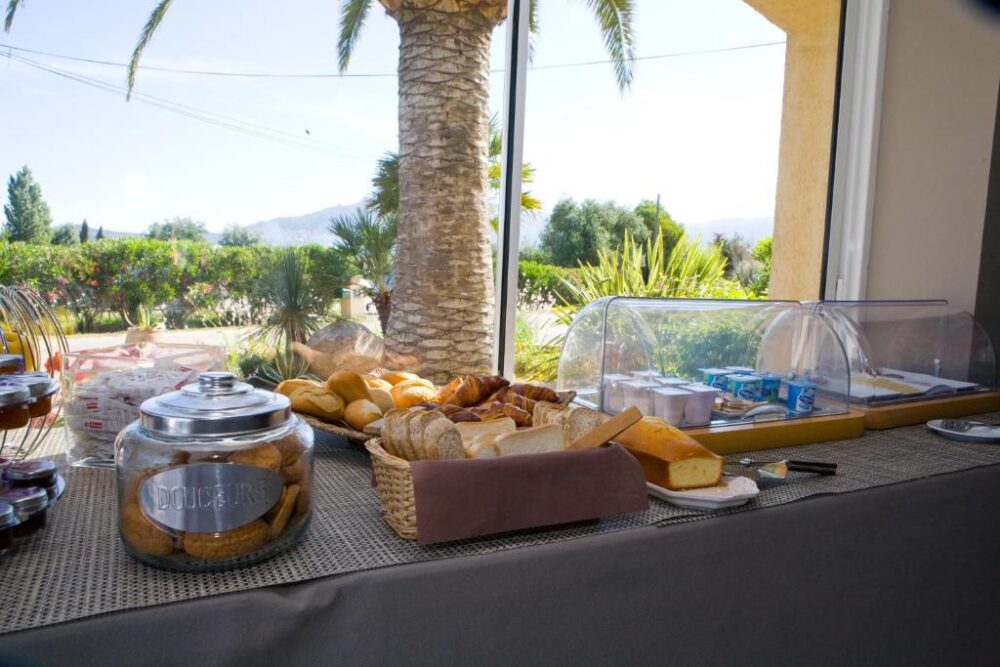 Buffet de petit-déjeuner avec vue sur jardin tropical.