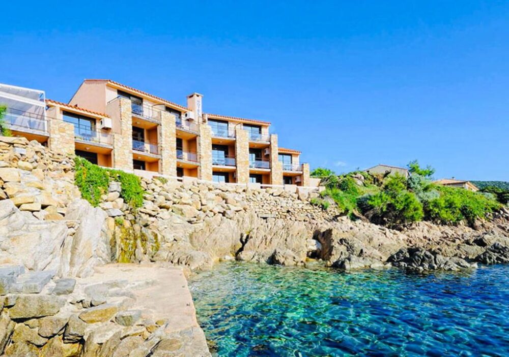 Immeuble surplombant un rivage rocheux et la mer