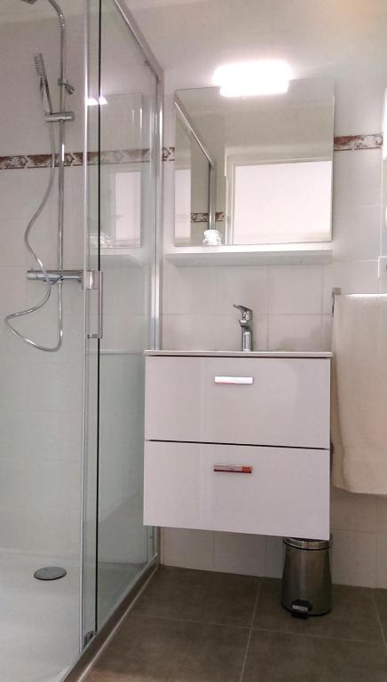 Salle de bain moderne avec douche vitrée.