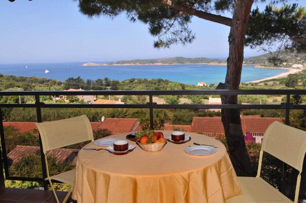 Terrasse avec vue sur mer et fruits.