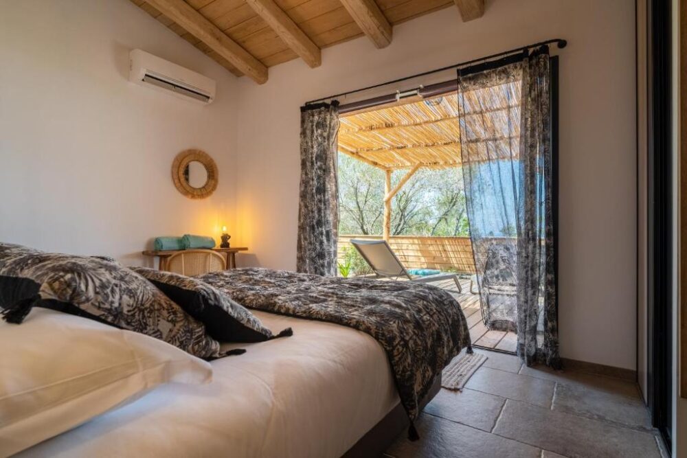 Chambre avec terrasse ensoleillée et vue extérieure.