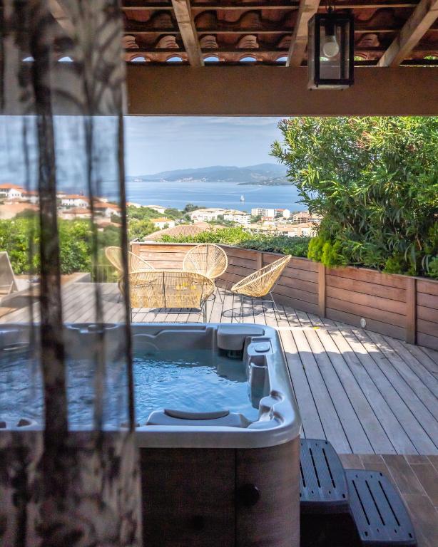 Terrasse avec jacuzzi vue sur mer.