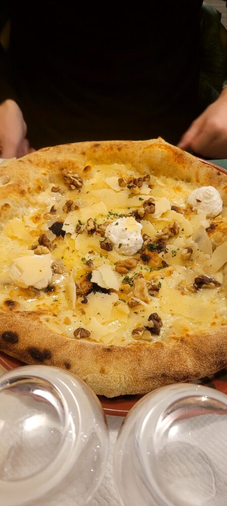 Pizza aux noix et fromage sur une table.