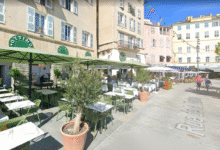 Terrasse de café avec parasols verts.