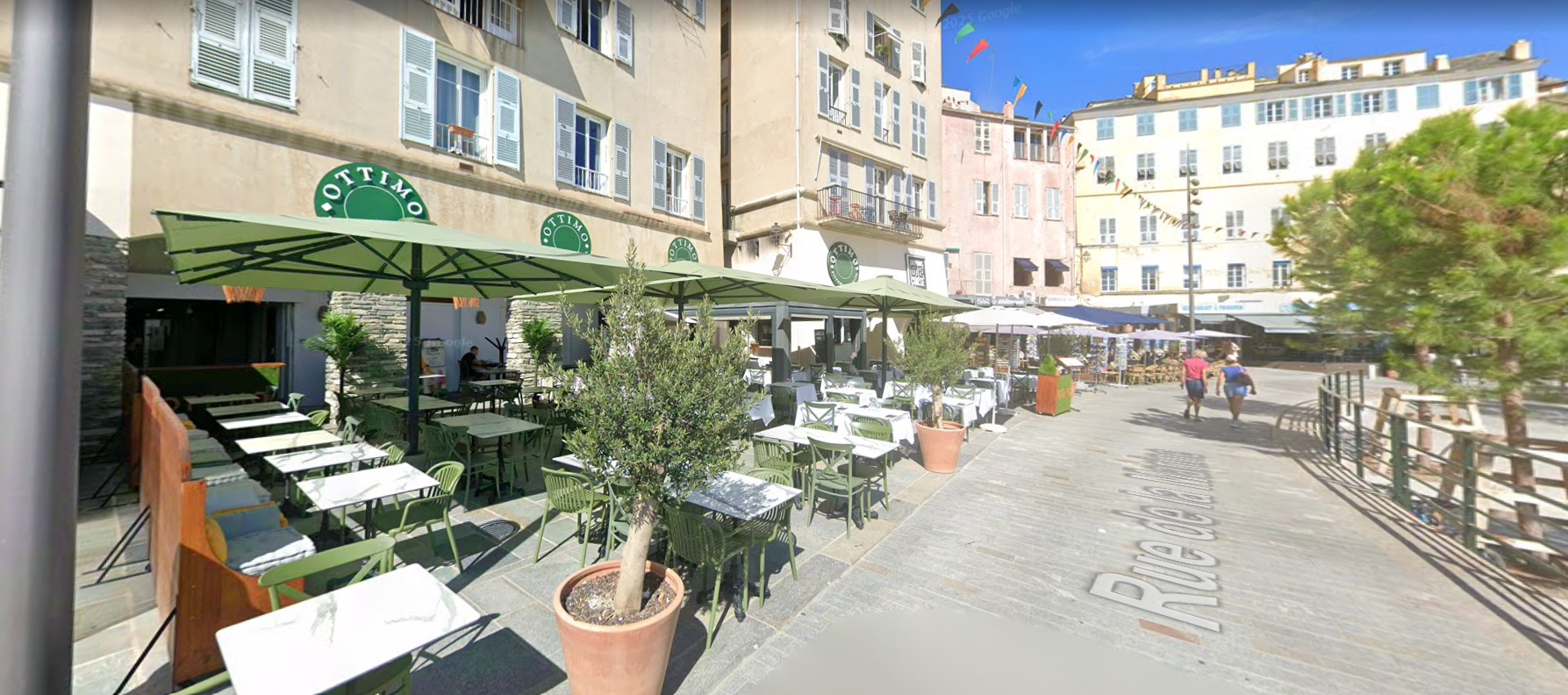 Terrasse de café avec parasols verts.