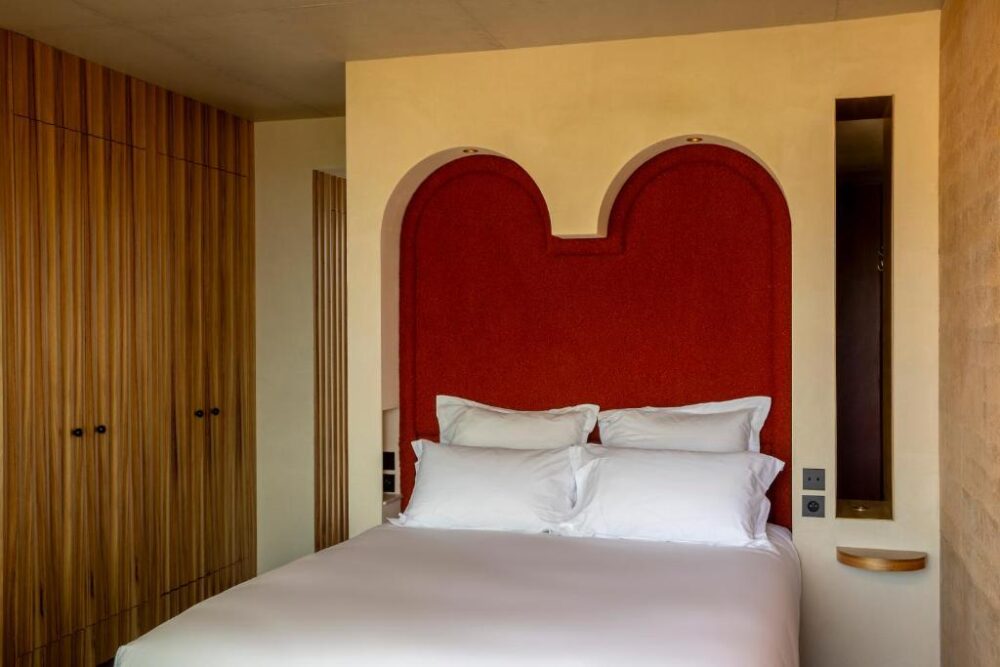 Chambre d’hôtel avec lit double et tête de lit rouge