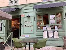 Façade verte du Café Cascade avec terrasse